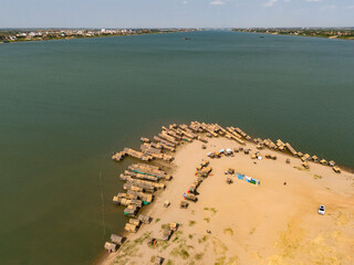 Aerial view of serene Silk Island with traditional huts and a winding river, Phnom Penh, Cambodia.