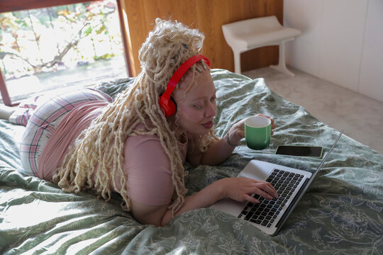 Woman using laptop on bed
