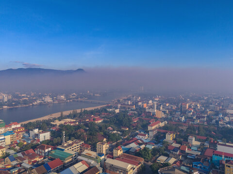Aerial view of cityscape with smoke from fire in the Bokor Mountain and river, Kampong Kandal, Kampot, Cambodia.