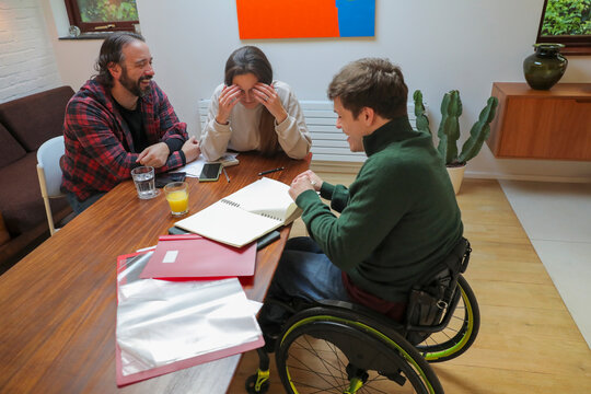 Smiling disabled people doing paperwork at home