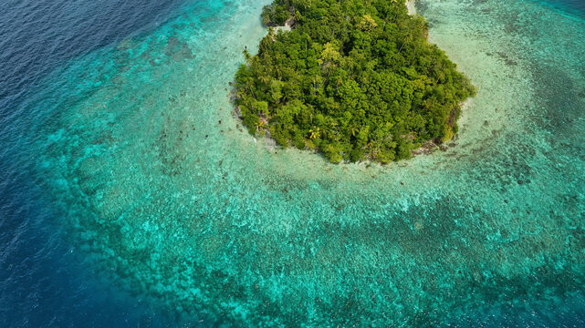 Aerial view of a tropical island with turquoise waters and vibrant coral reefs, Western Province, Solomon Islands.