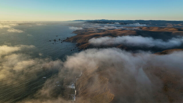 Aerial view of the serene and picturesque coastline with waves and fog, Point Reyes, Dillon Beach, California, United States.