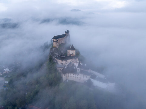 Aerial view of Orava Castle shrouded in fog at sunrise, Oravsky Podzamok, Zilina, Slovakia.
