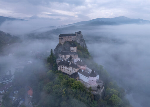 Aerial view of Orava Castle shrouded in fog at sunrise, Oravsky Podzamok, Zilina, Slovakia.