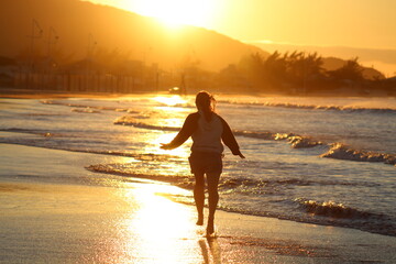 silhueta de mulher correndo na beira da praia em palho&ccedil;a, santa catarina 