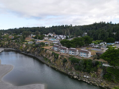 Aerial view of scenic Gualala River with picturesque houses and tranquil forest along the rocky coast, The Sea Ranch, California, United States.