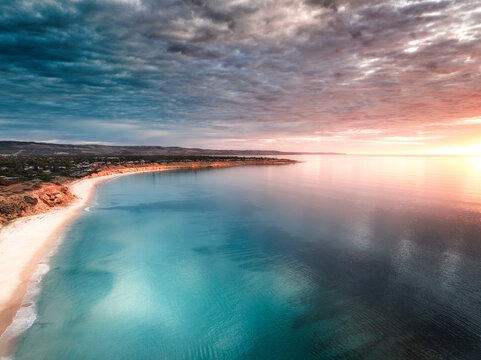 Aerial view of cliffs and coastline at sunset with ocean and clouds, Port Willunga, South Australia, Australia.
