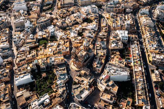 Aerial view of St. Mary's Parish Church surrounded by historic buildings and quaint streets, Dingli, Malta.