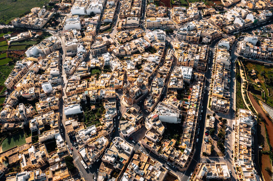 Aerial view of St. Mary's Parish Church surrounded by charming rooftops and dense streets in a picturesque town, Dingli, Malta.
