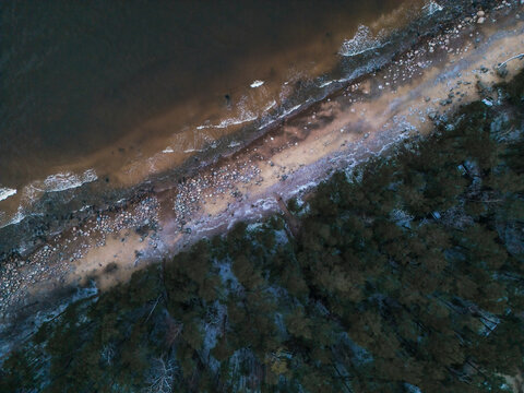 Aerial view of the tranquil baltic sea coastline with serene beach, forest, and waves, Salacgriva Parish, Limbazi, Latvia.