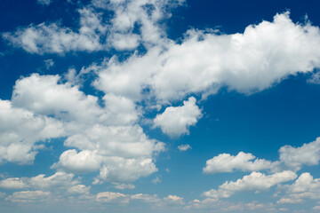 beautiful blue sky with fluffy white clouds, a stunning photograph of a clear blue sky adorned with fluffy, white clouds, perfect for backgrounds, greeting cards, and uplifting visuals