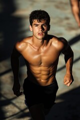 Young muscular athlete running under the sunlight