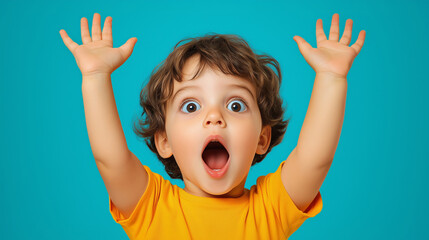Portrait of a surprised, cute little boy raising his hands with a shocked facial expression on a blue background, front view. 