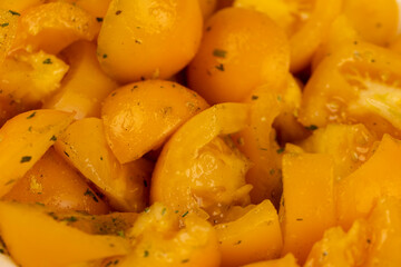 ripe orange tomatoes with spices cut into pieces of different sizes