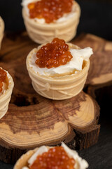 a quick snack from a waffle cup with buttercream and natural red caviar