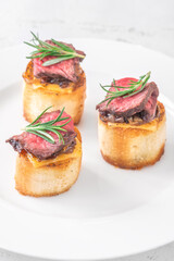 Grilled baguette sandwich with melted cheese, juicy steak, caramelized onions, and rosemary