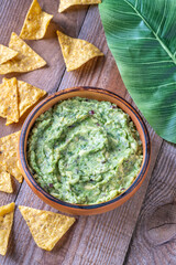 Guacamole with Tortilla Chips on Rustic Wooden Table with Leaf
