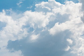 Bright cumulus clouds against a blue sky.