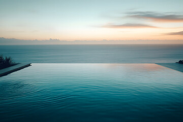 Fototapeta premium A high-angle shot of a luxury hotel infinity pool overlooking the ocean at sunset