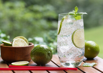 Glass of sparkling water with lime slices and mint leaves
