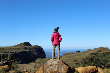 Naklejka premium mulher de casaco rosa com cânion ao fundo no Cânion do Espraiado em Urubici, Santa Catarina
