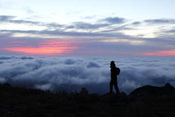 homem em mirante com mar de nuvens no amanhecer 