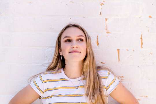 teen standing against brick wall