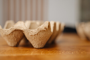 A cardboard egg tray placed on a rustic wooden table, ideal for farm, grocery, eco-friendly packaging