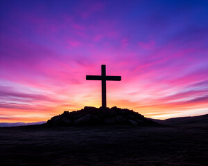 Silhouette cross on a hilltop at sunrise