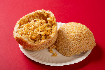 angle view traditional Chinese fried sesame ball on red at horizontal composition