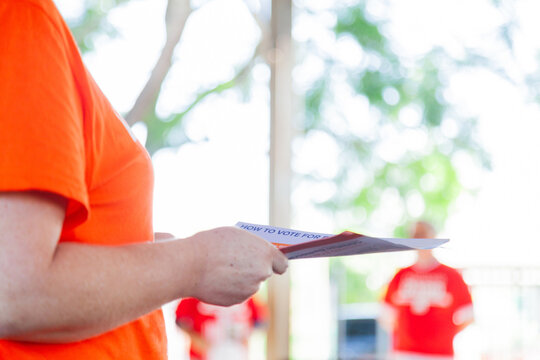 Volunteer for political party handing out how to vote papers