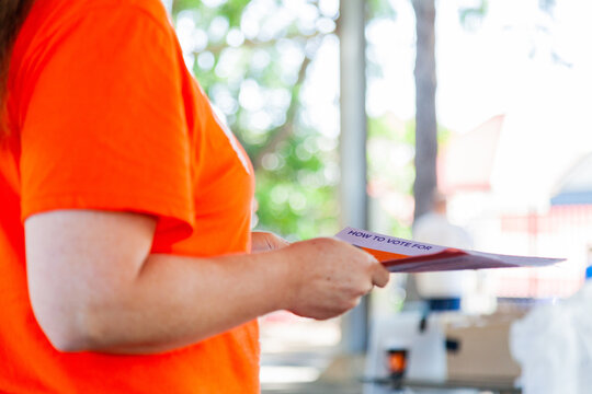 Volunteer for political party handing out how to vote papers