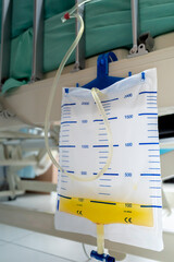 Urinary catheter measurement bag hung on the side of patient bed in hospital ward