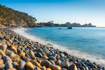 Beach in Korea with round rocks and a long exposure water  tide at sunrise