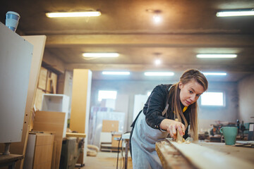 Obraz premium Young Woodworker Finishing Furniture in a Workshop with Focus and Precision