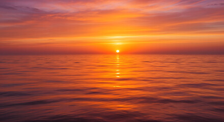 A stunning sunset over the ocean, with warm orange and pink hues reflecting on the water.