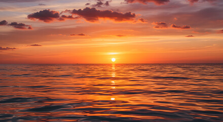 A stunning sunset over the ocean, with warm orange and pink hues reflecting on the water.