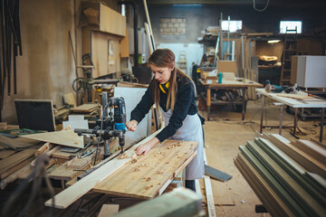 Young Woman Working in a Carpentry Workshop Using Power Tools