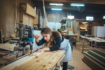 Woman Working with Power Tool in a Woodworking Workshop