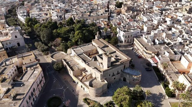 Drone footage capturing a historic castle in Nardo, Italy, surrounded by a dense old town and lush greenery