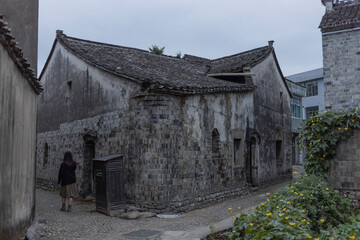 Fototapeta premium The scenic view of a small alley street in the ancient town of Qiantong, China, under the twilight of dusk