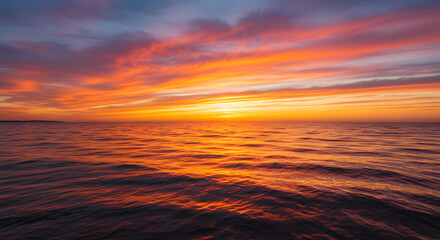 A stunning sunset over the ocean, with warm orange and pink hues reflecting on the water.