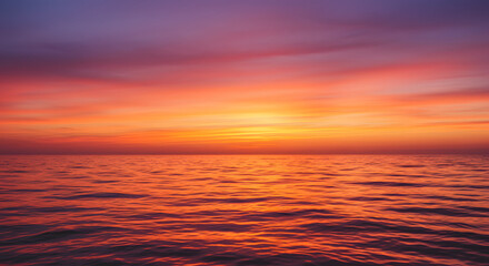 A stunning sunset over the ocean, with warm orange and pink hues reflecting on the water.