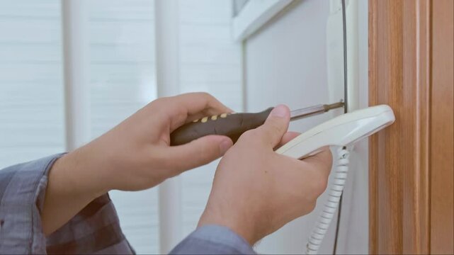 Low-voltage system professional performs diagnosis, replacement, and setup of intercom components, ensuring its efficient operation.