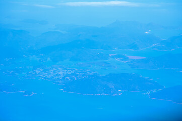 Looking from the airplane window with Hong Kong cityscape. The view of Hong Kong city, Hong Kong landscape from the above. Landscape, travel concept and nature scene. 