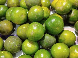 several green oranges in the same container