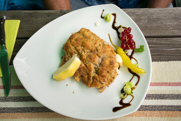 Cutlet pork or batter fried pork steak with sauce and vegetable and berry fruit on ceramic plate serve dining in restaurant