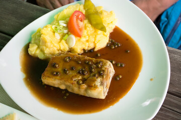Steak pork and gravy sauce with boiled vegetable mix and Mashed Potato on ceramic plate serve dining in restaurant