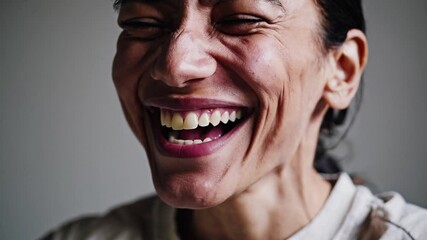 Close-up portrait of a young man laughing heartily with genuine joy and happiness. A candid and expressive moment of pure, infectious laughter and positive emotion.