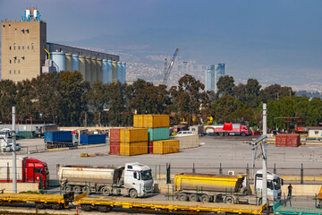Turkiye, Izmir - March 1, 2024: Aerial view of Port of Liman filled with vibrant cargo containers, cranes, and busy dock operations under a clear blue sky.
